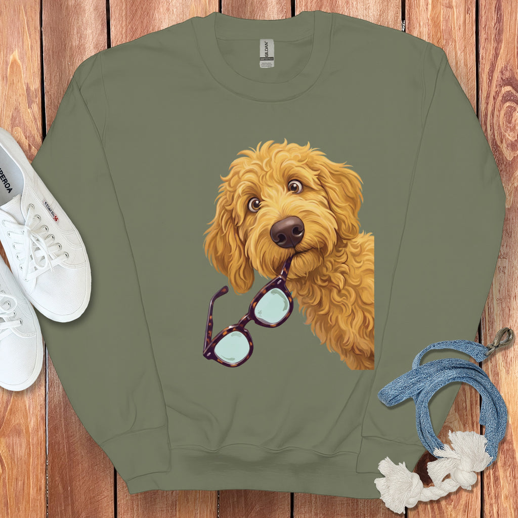 Olive green crewneck sweatshirt featuring a graphic of a golden doodle dog holding glasses in its mouth.