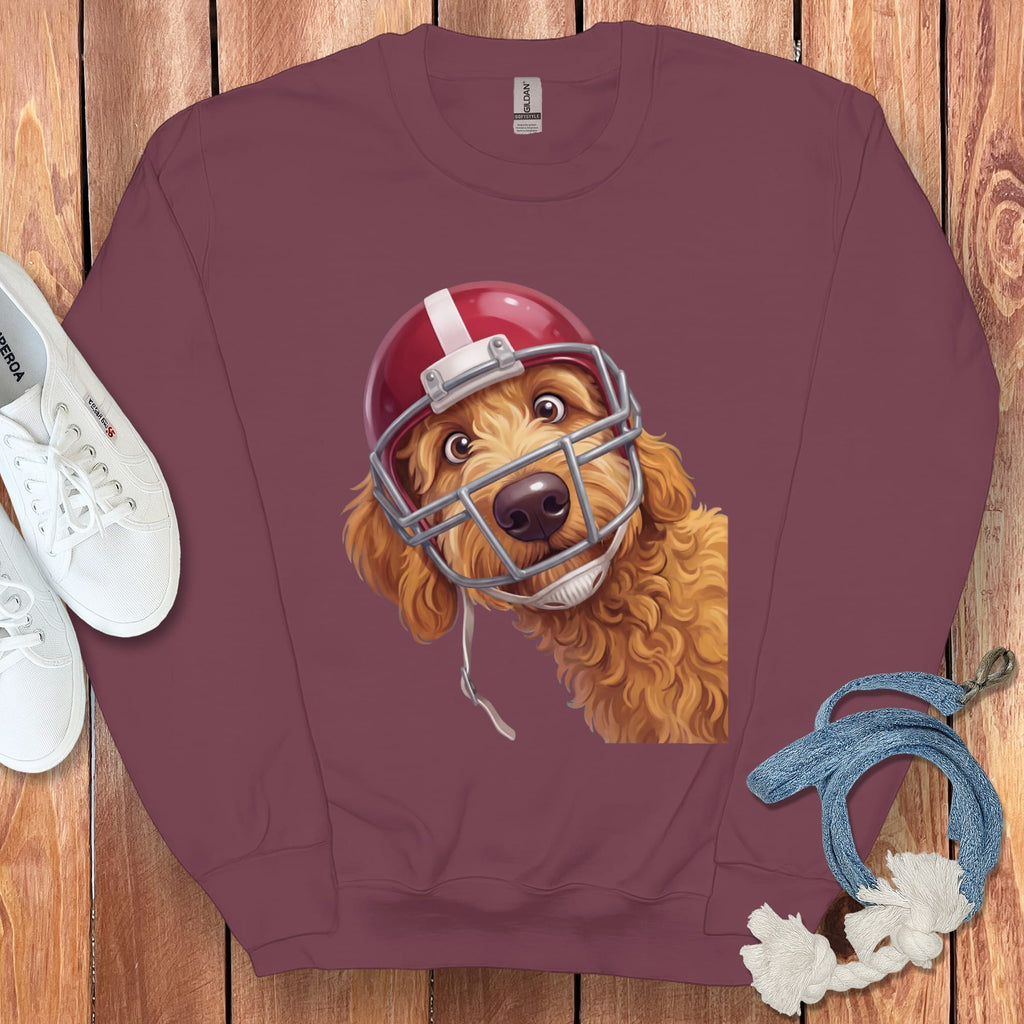 Maroon sweatshirt with a cartoon goldendoodle wearing a red football helmet.