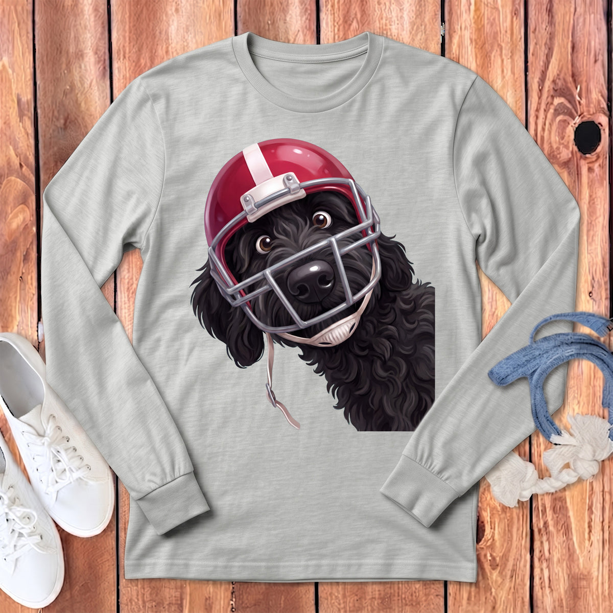 Black dog wearing a red and white football helmet on a gray long-sleeve shirt.