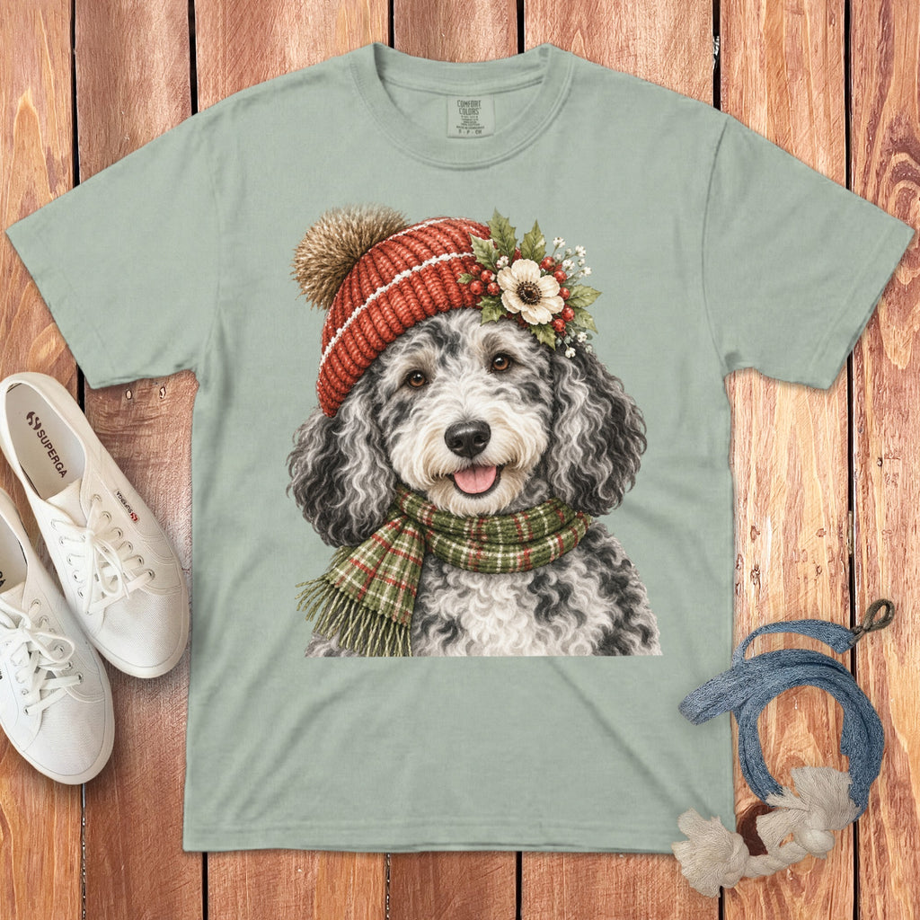 Light green t-shirt with watercolor art of a dog wearing a festive hat and scarf.