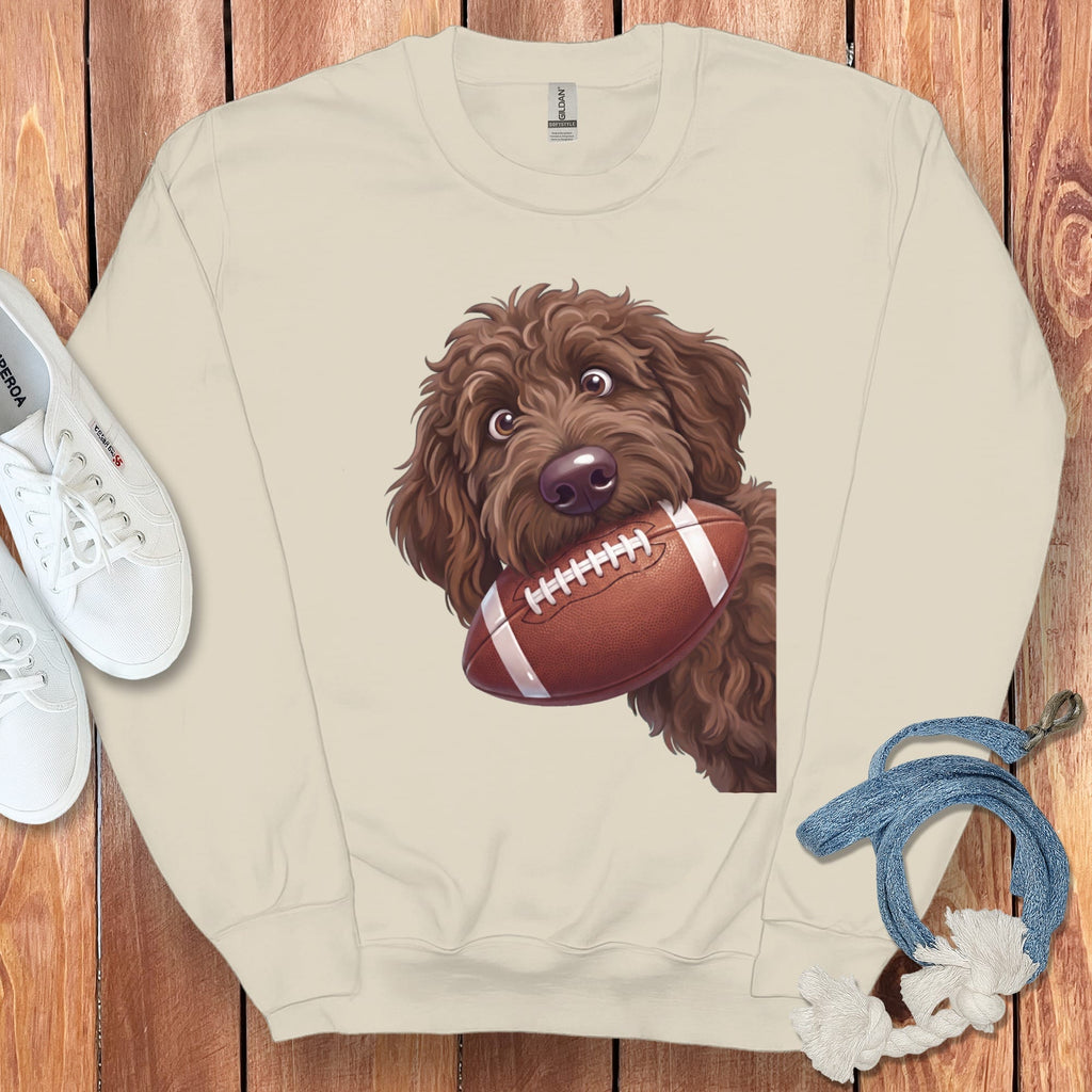 Crewneck sweatshirt with a brown doodle dog holding a football in its mouth.