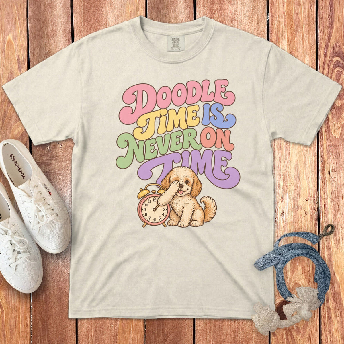Off-white t-shirt featuring retro text reading Doodle Time is Never on Time above an illustrated puppy with an alarm clock.