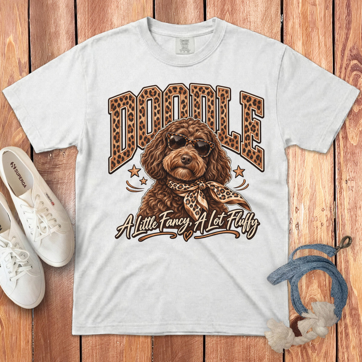 White t-shirt with "DOODLE" in leopard print and a dog wearing sunglasses and a scarf.