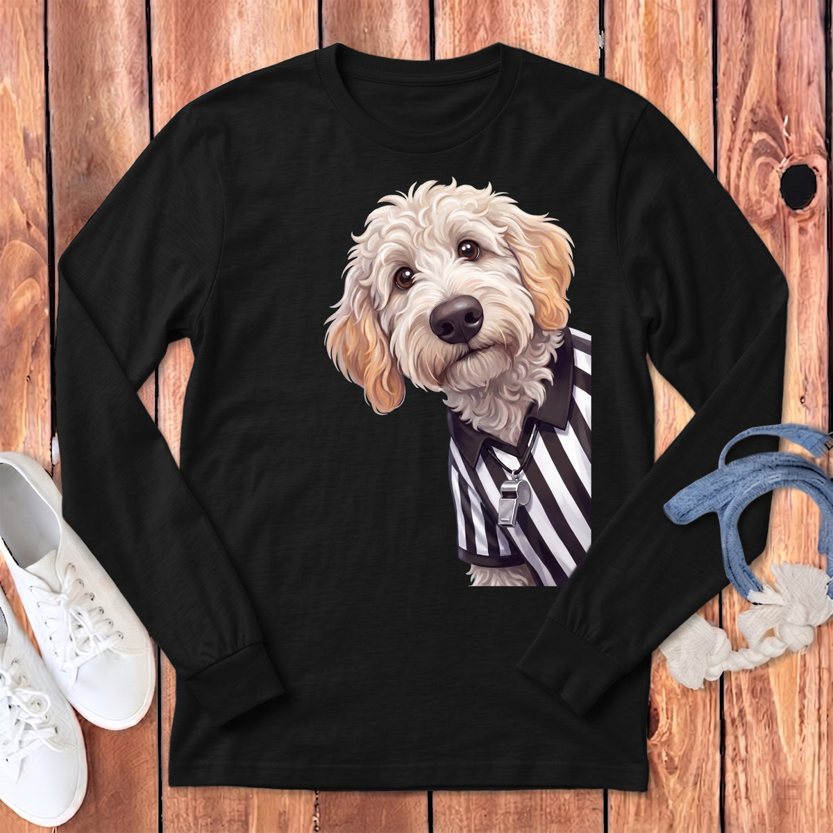 Goldendoodle wearing referee shirt with whistle on black long-sleeve shirt.