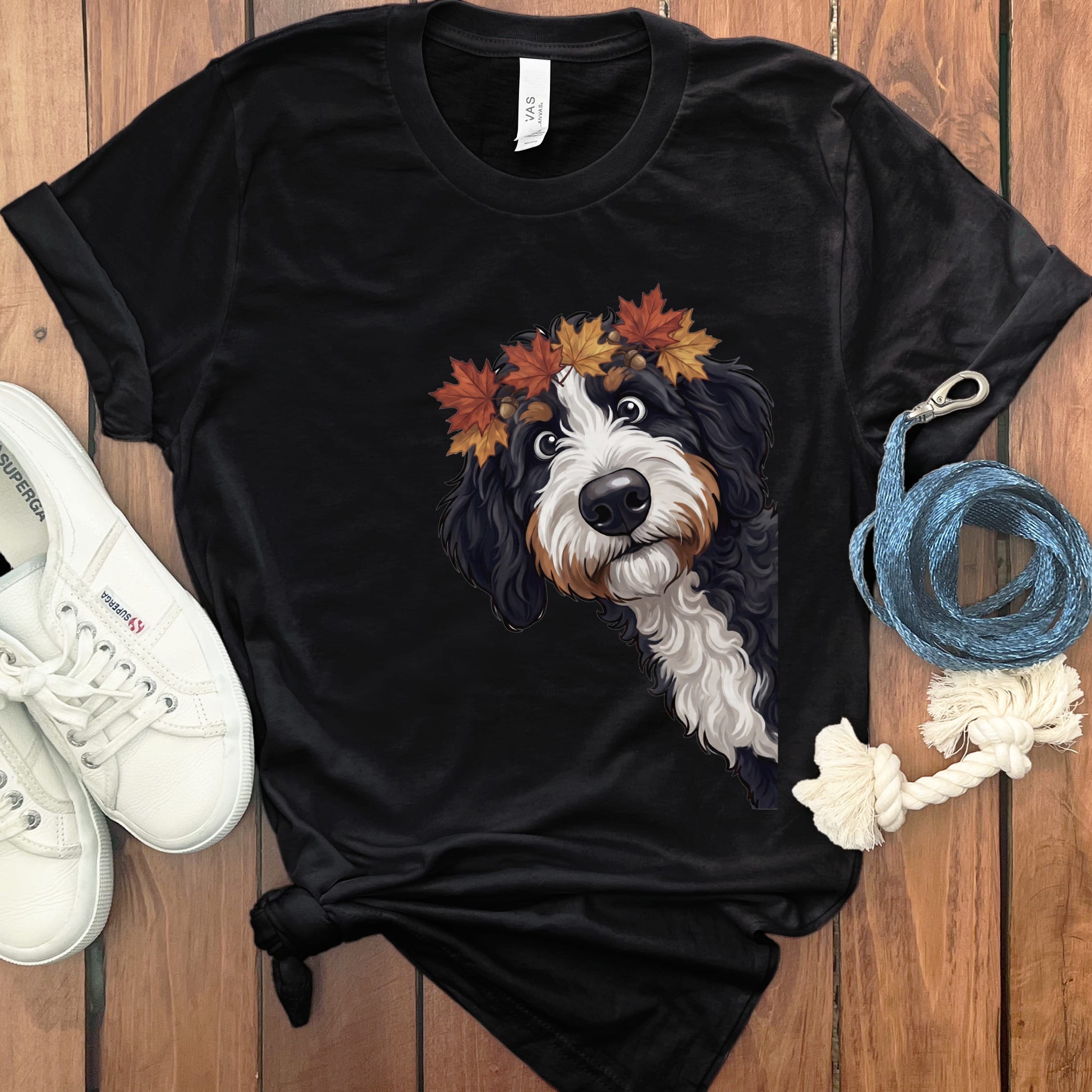 Black t-shirt featuring a Bernese Mountain Dog wearing a wreath of autumn leaves.