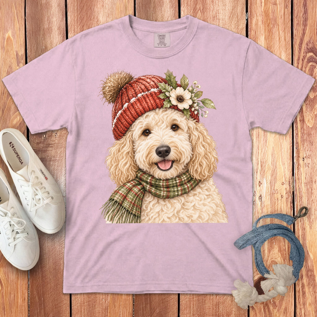 Pink t-shirt with a watercolor painting of a happy doodle dog wearing a festive hat and scarf.