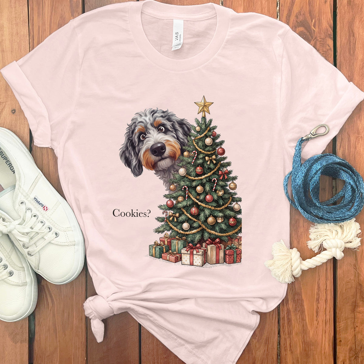 Dog peeking from behind a Christmas tree with gifts, text "Cookies?".
