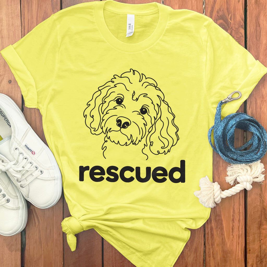 Yellow t-shirt with a line drawing of a dog's head and the word "rescued."