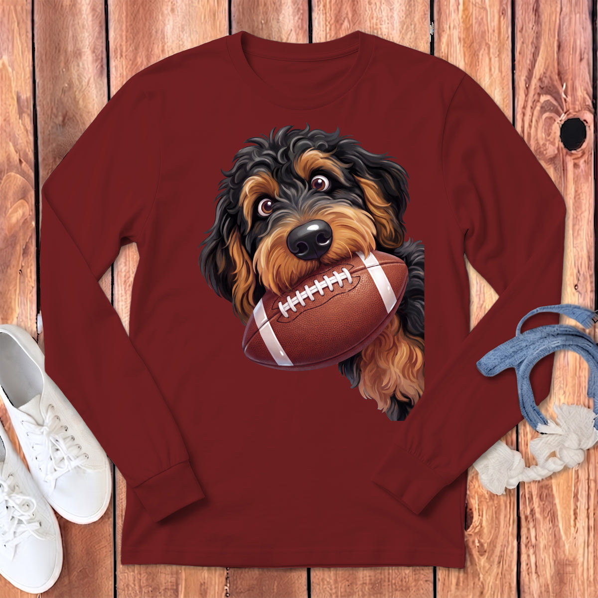 Maroon long sleeve shirt featuring a cartoon dog holding a football in its mouth.