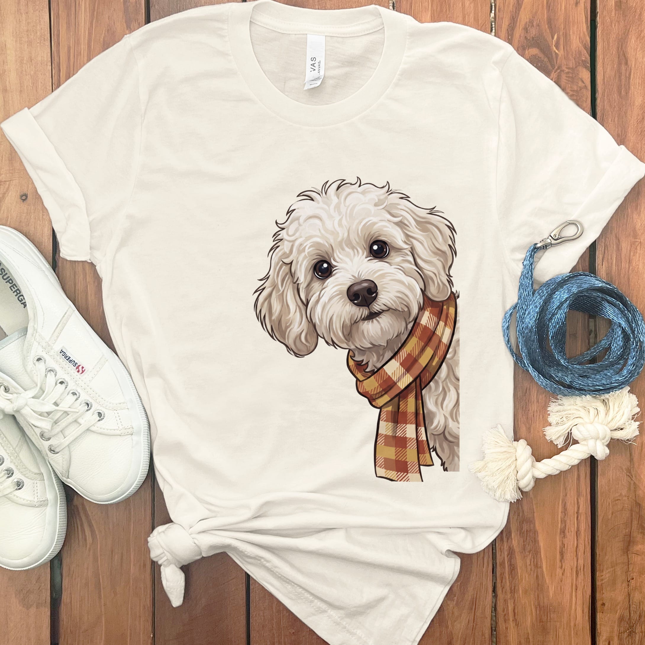 Cream t-shirt with illustration of a fluffy white dog wearing a plaid scarf