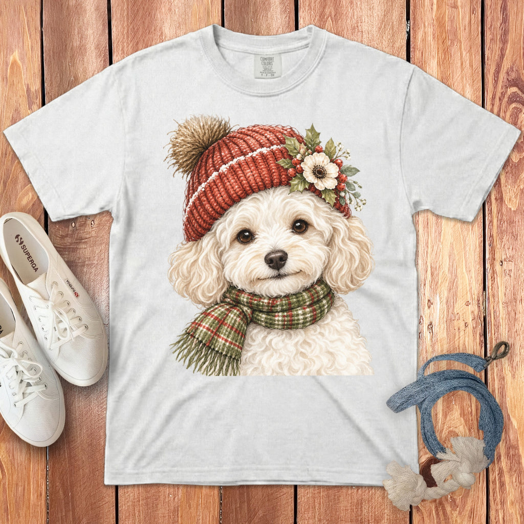 White t-shirt with a watercolor illustration of a fluffy white dog wearing a red hat and scarf.