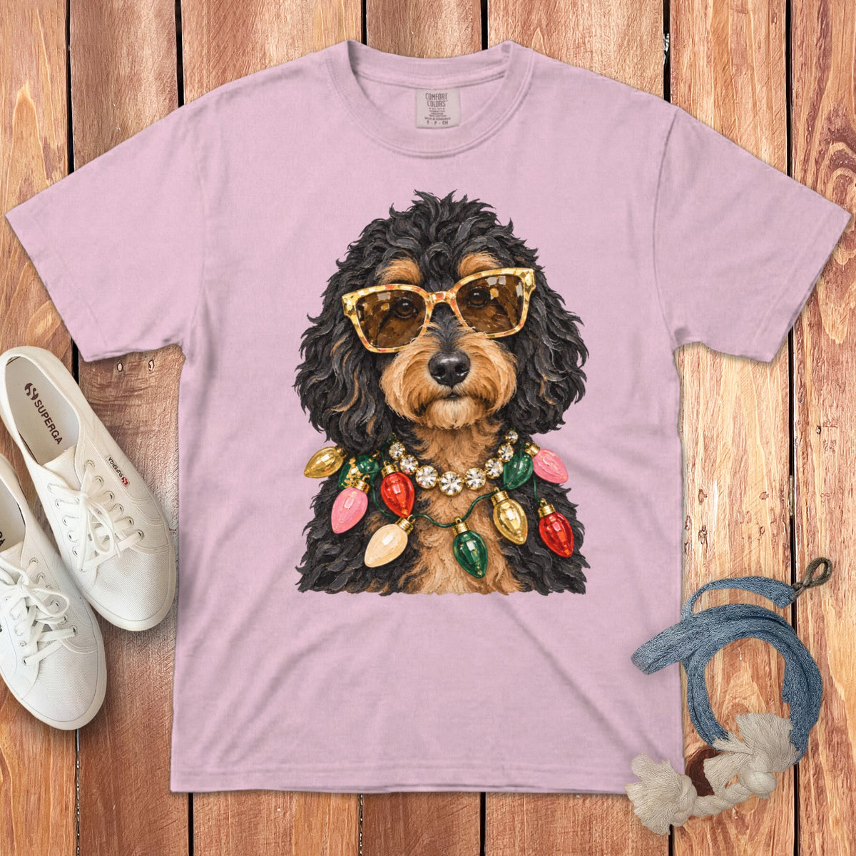 Pink t-shirt with graphic of a dog wearing sunglasses and Christmas lights.