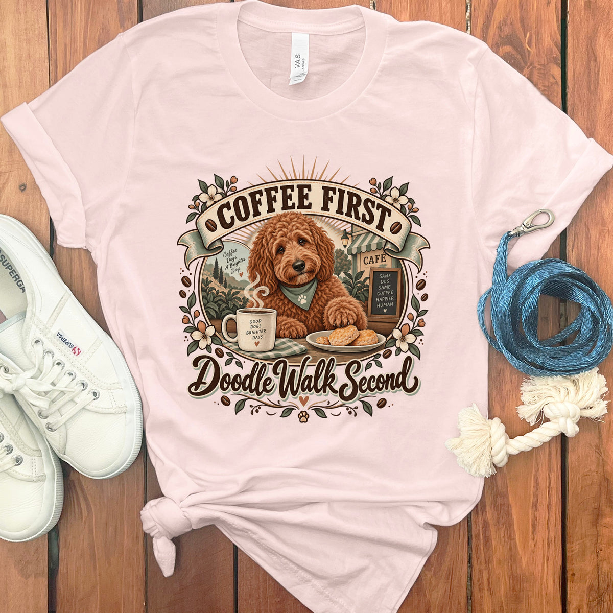 Light pink t-shirt with a doodle graphic that says "Coffee First, Doodle Walk Second".
