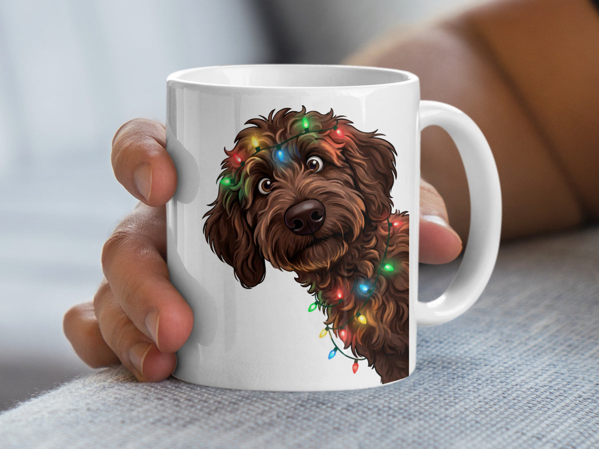 White mug with a brown doodle dog wearing colorful Christmas lights.