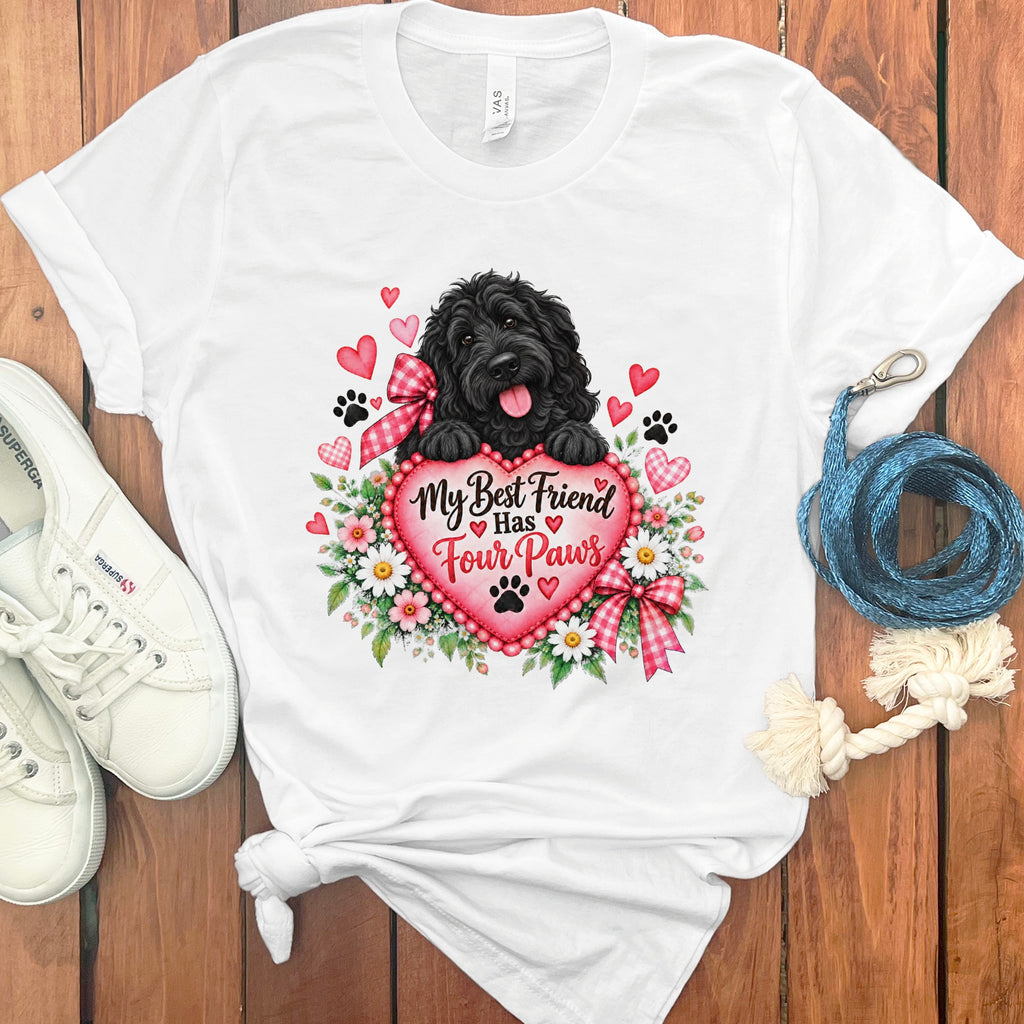 A white t-shirt featuring a graphic of a black dog holding a pink heart with flowers.