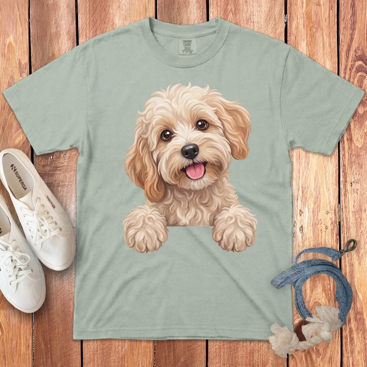 Light green t-shirt with a watercolor illustration of a fluffy dog's face.