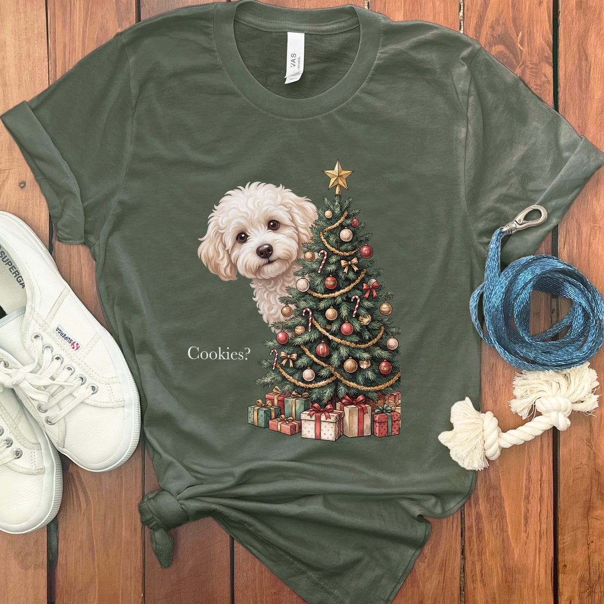 White fluffy dog peeks from behind a Christmas tree asking "Cookies?".