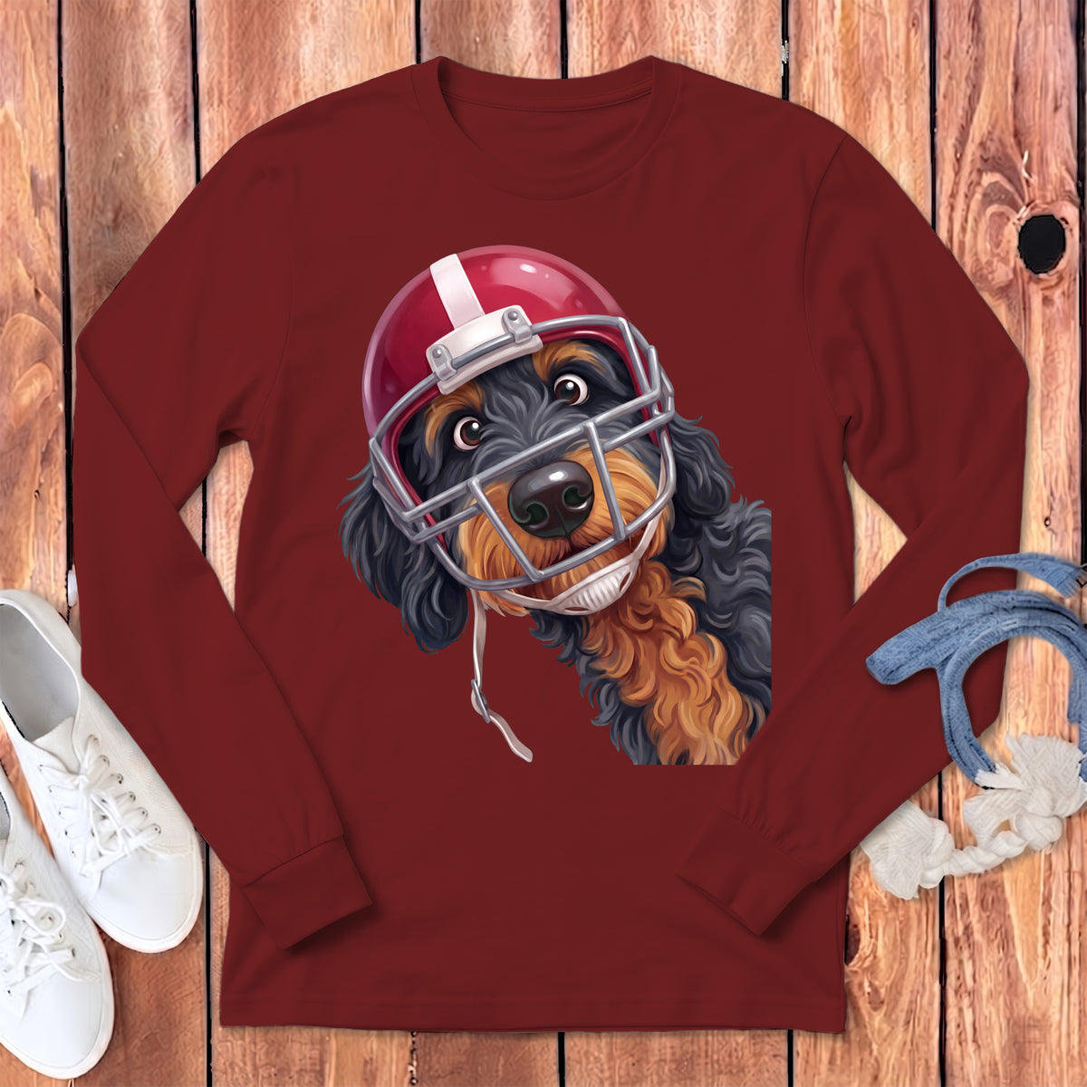 Dog wearing a red football helmet and uniform on a maroon long-sleeve shirt.