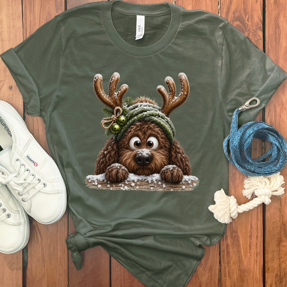 Green t-shirt with a brown cartoon dog wearing reindeer antlers and a knit hat.