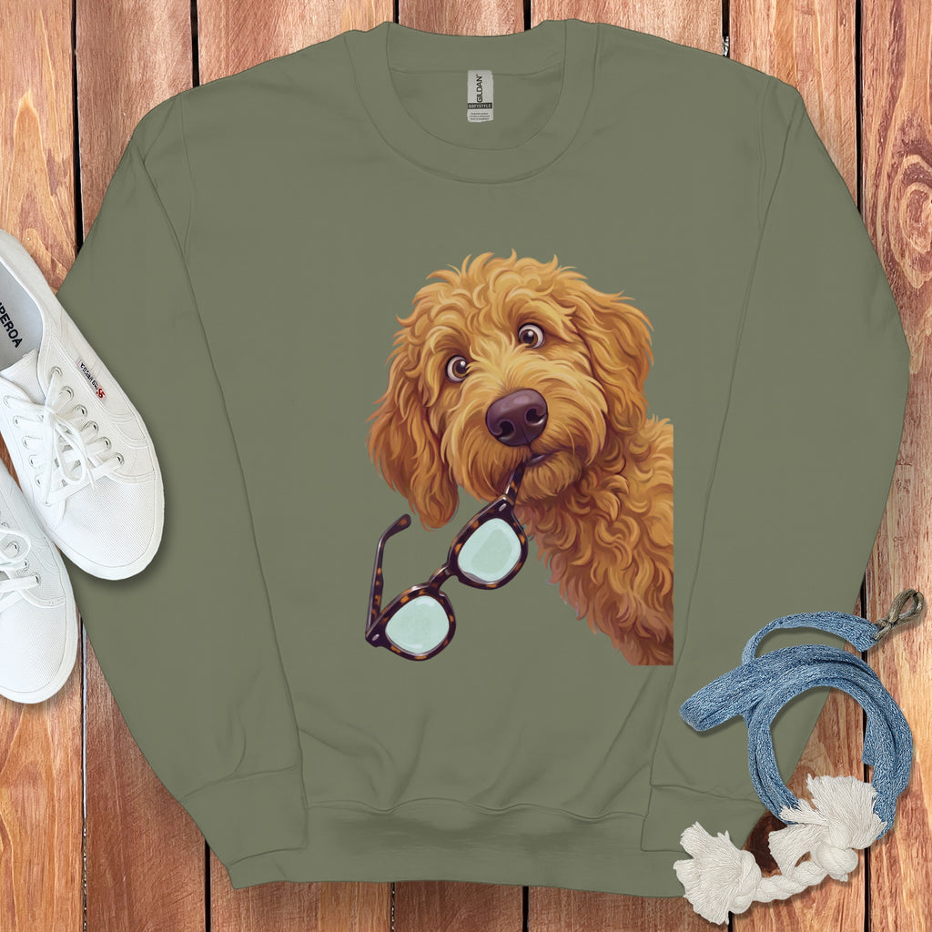 An olive green crewneck sweatshirt featuring a graphic of a golden doodle dog holding glasses.