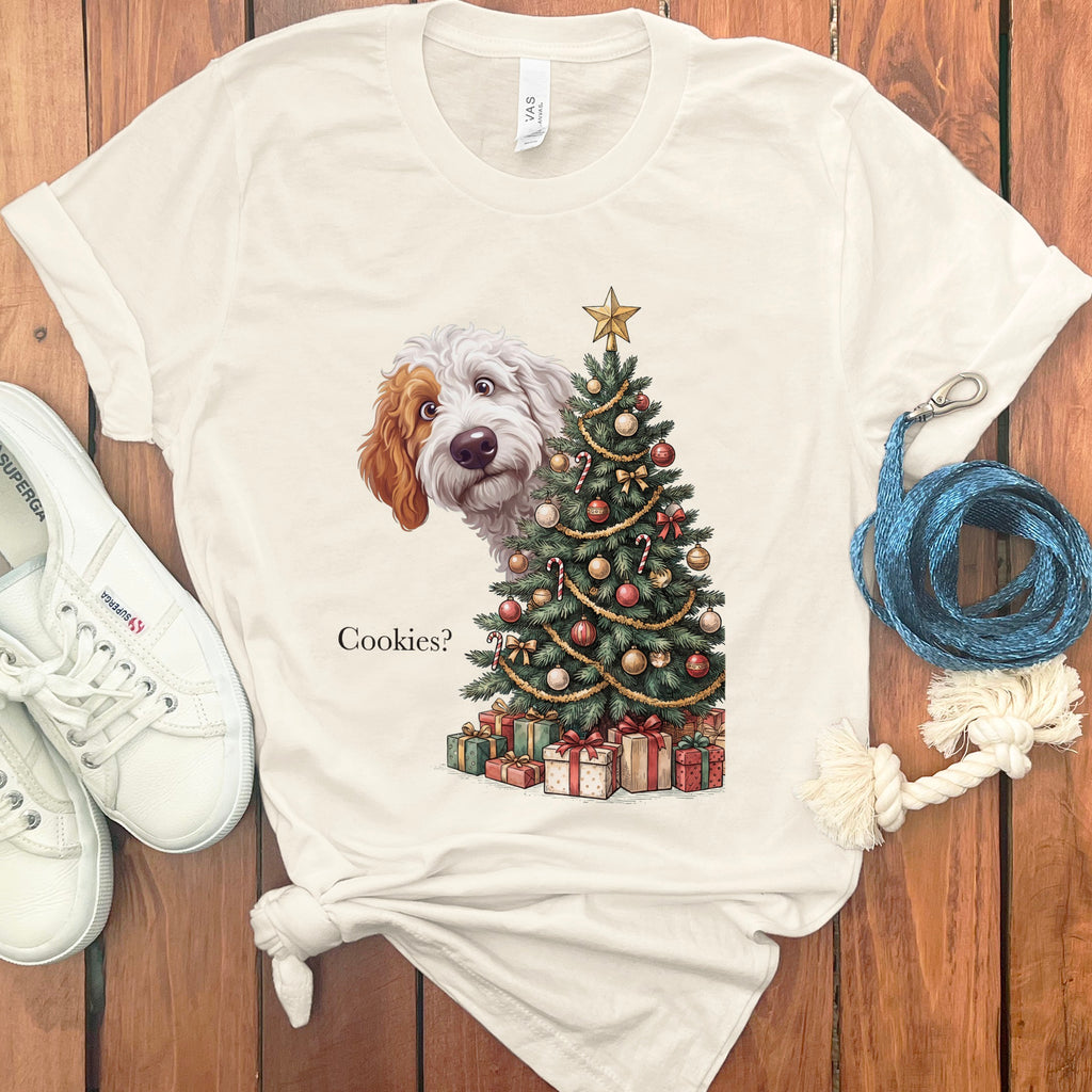 Cream t-shirt with a doodle dog peeking from behind a Christmas tree that asks "Cookies?".