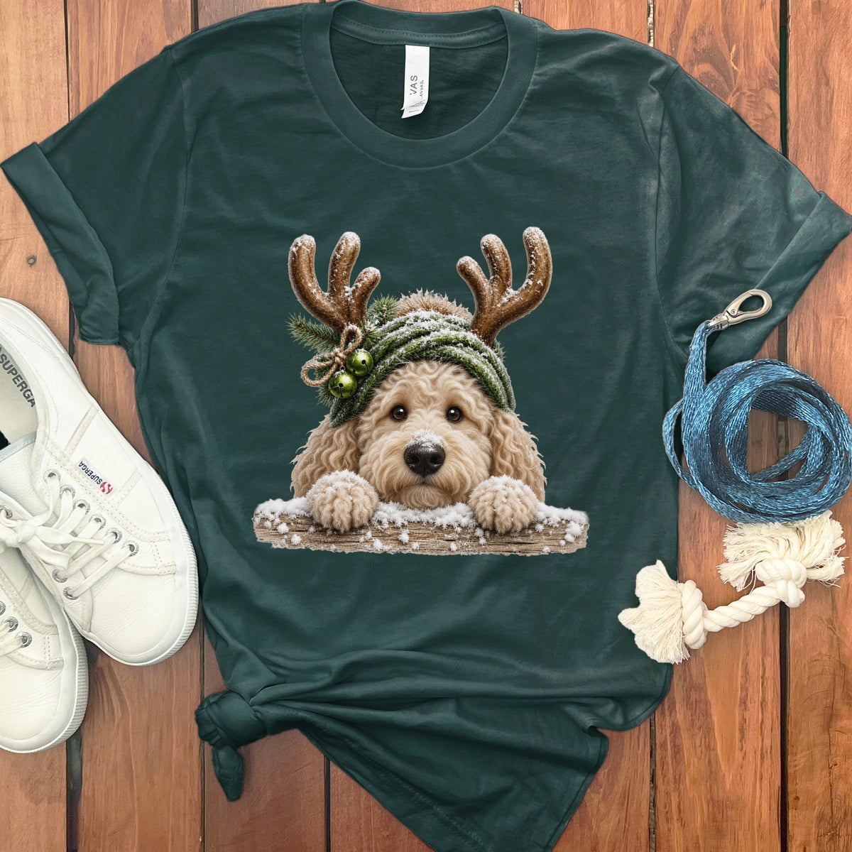 Dark green t-shirt with a fluffy dog wearing reindeer antlers and a knit hat.
