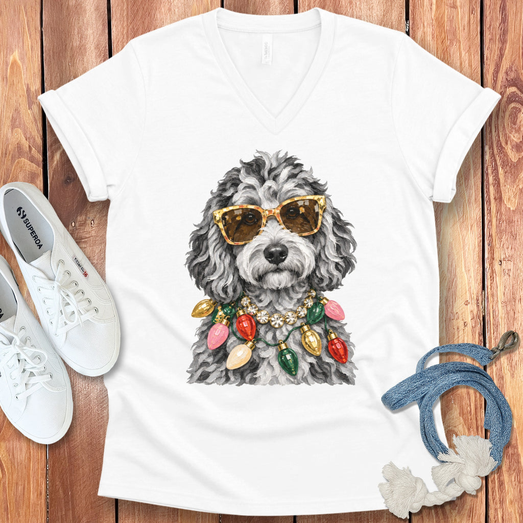 White v-neck t-shirt with watercolor art of a fluffy dog wearing sunglasses and Christmas lights.