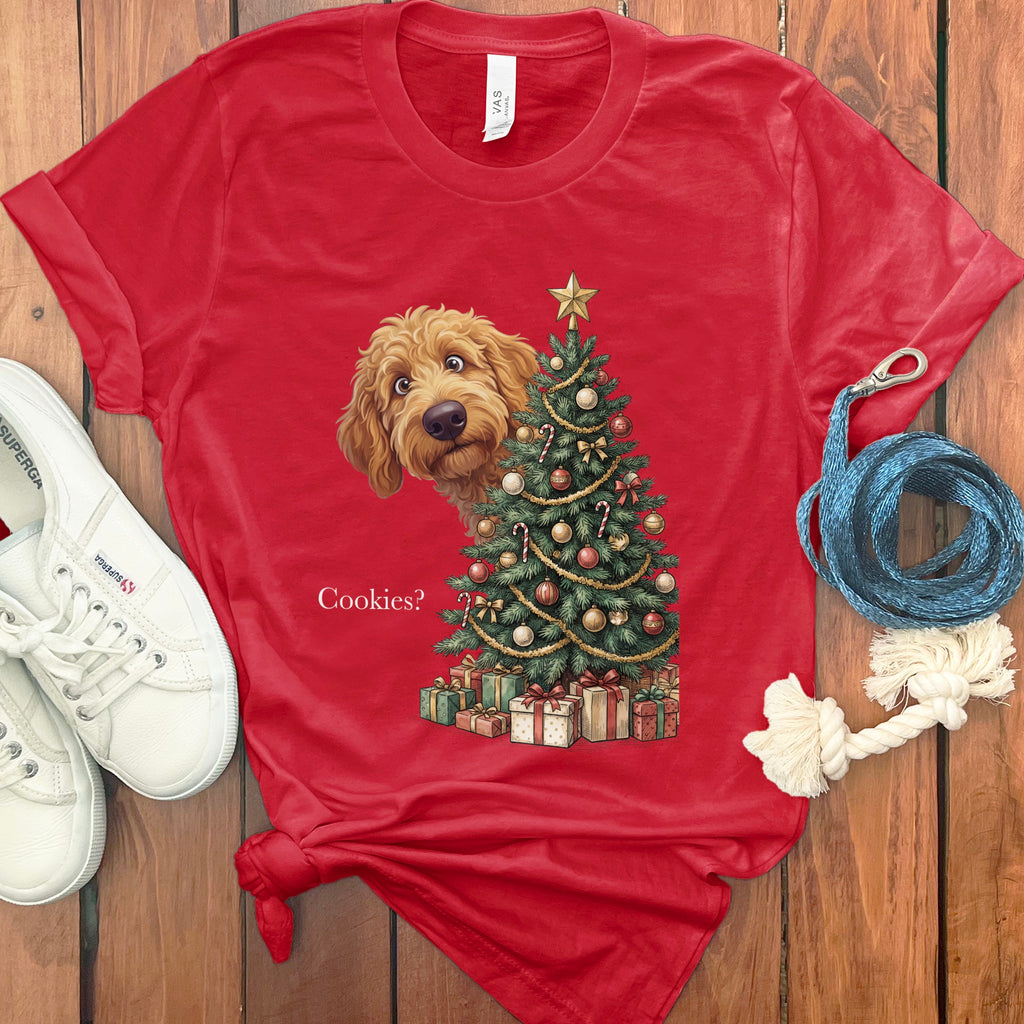 Golden doodle peeks from behind a Christmas tree with gifts and the text "Cookies?".