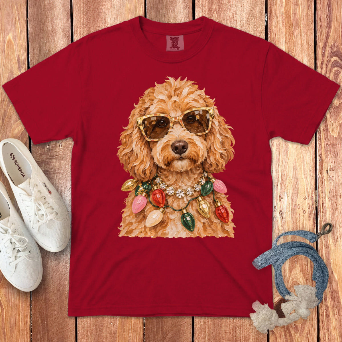Red t-shirt with a doodle wearing sunglasses and a Christmas light necklace.