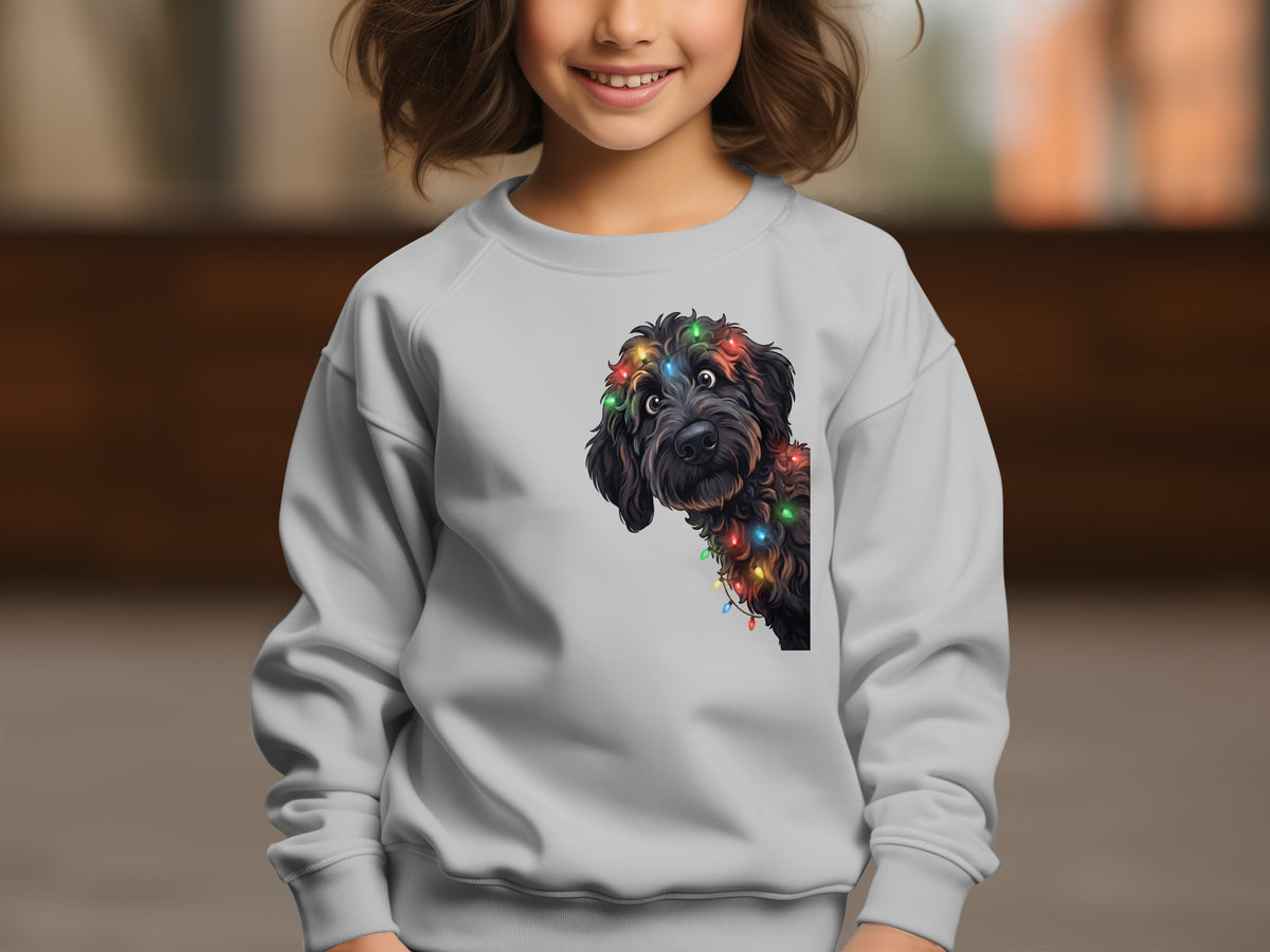 Child wearing light grey sweatshirt with a black dog wearing colorful Christmas lights on chest.