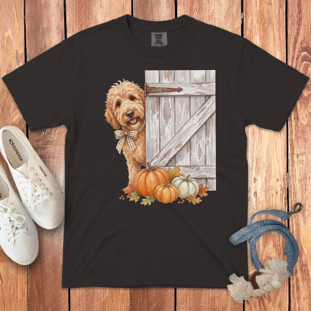 Brown t-shirt with a watercolor print of a dog peeking from behind a barn door with pumpkins.