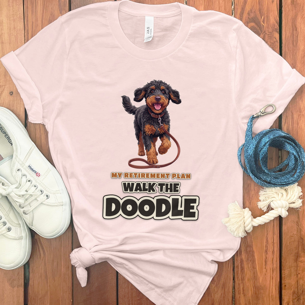 Pink t-shirt with illustration of a doodle dog and text "My Retirement Plan Walk The Doodle".