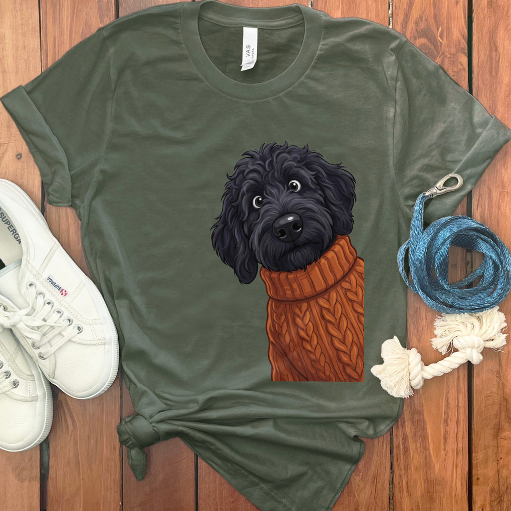 Green t-shirt featuring a black dog wearing an orange knitted sweater.