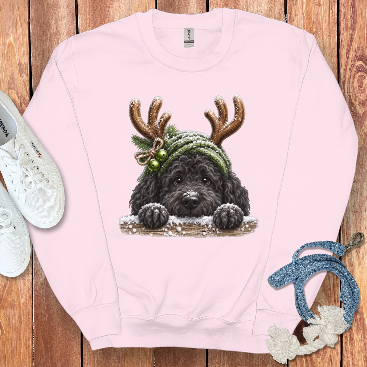 Pink sweatshirt with a black dog wearing antlers and a green hat.