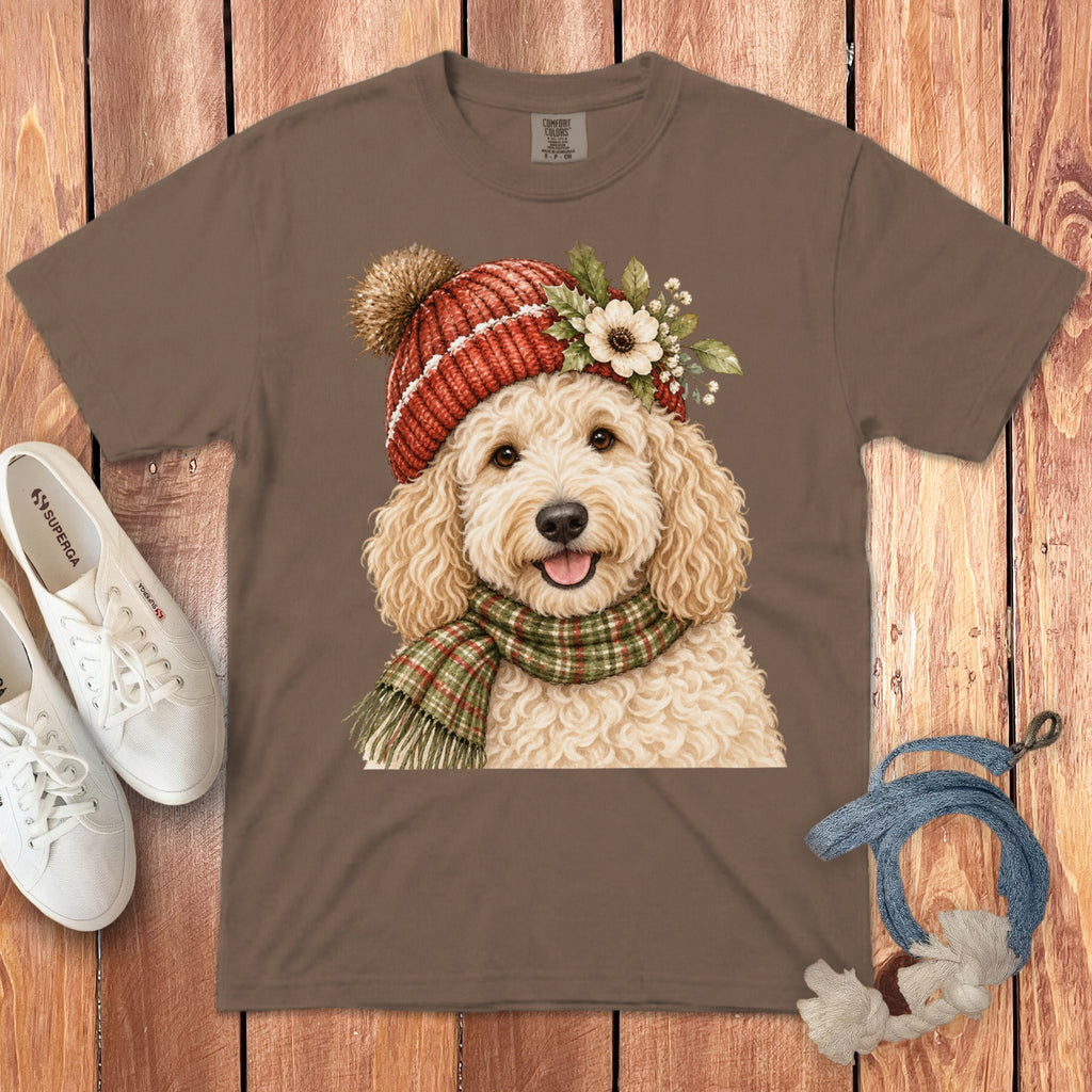 Brown t-shirt featuring a watercolor illustration of a fluffy goldendoodle wearing a red knit hat and scarf.