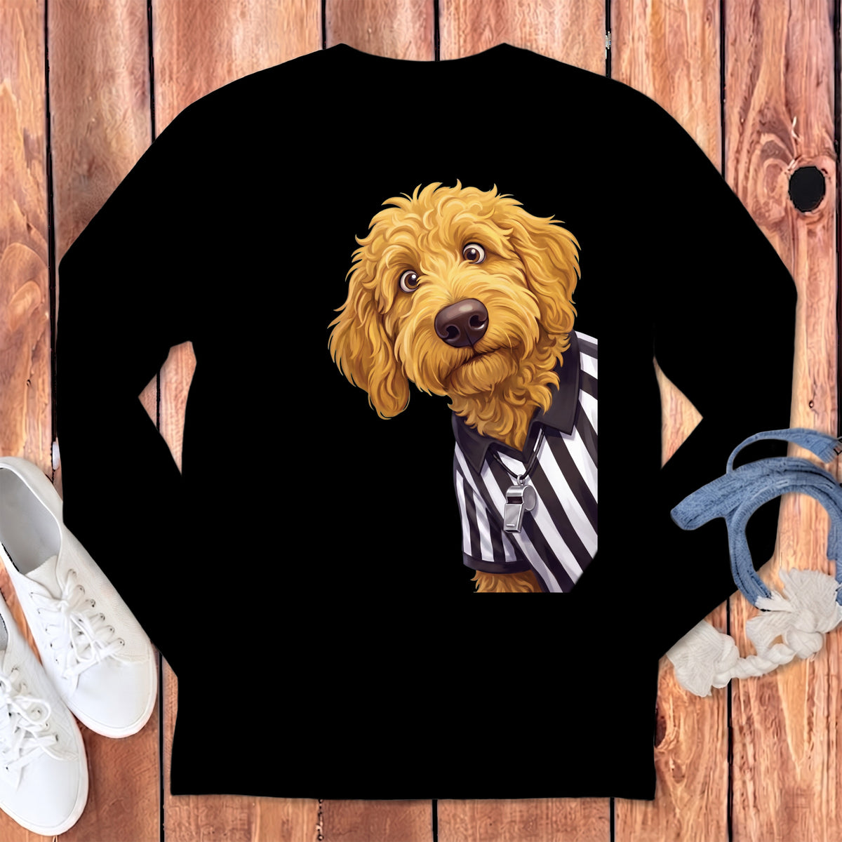 Golden doodle dog wearing a black and white striped referee shirt with a whistle.