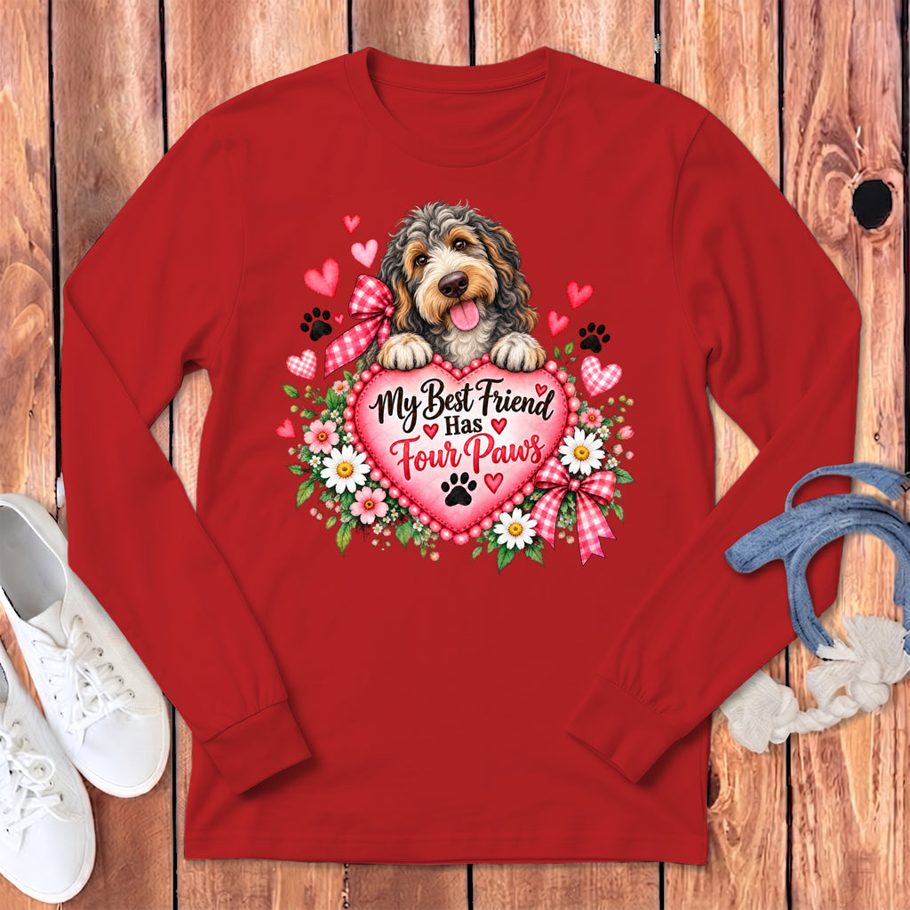 A red long-sleeved shirt featuring a fluffy dog resting on a heart with the text My Best Friend Has Four Paws.
