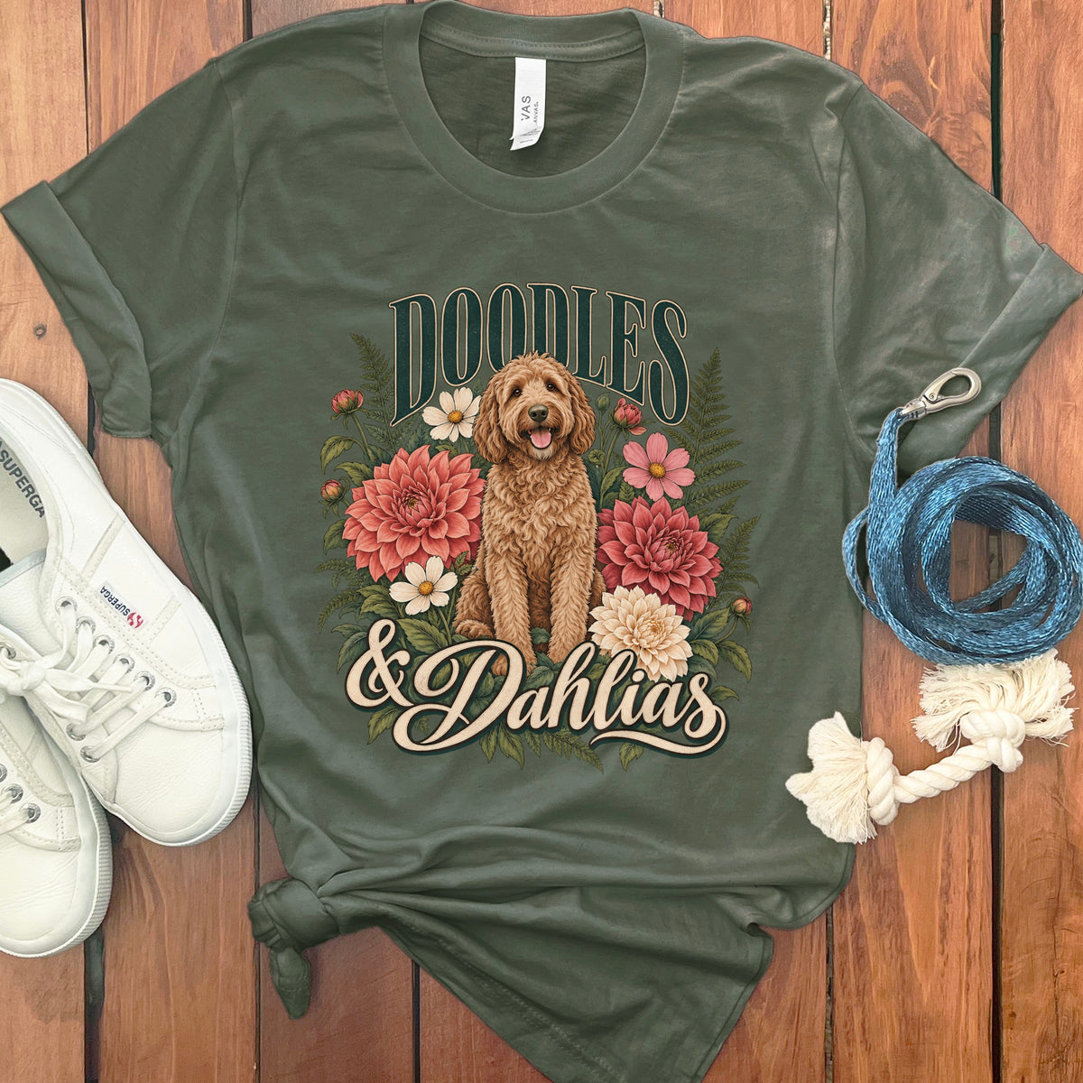 Green t-shirt with "Doodles & Dahlias" text and a doodle dog surrounded by flowers.
