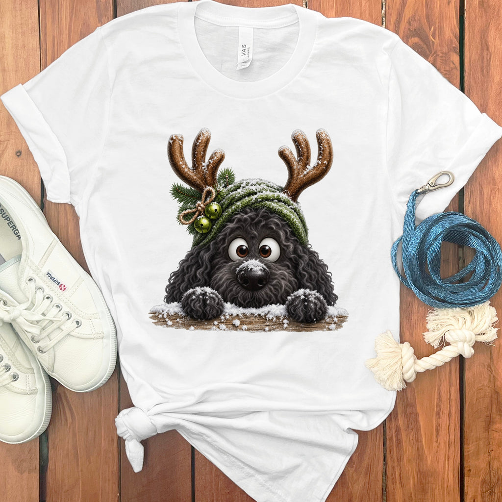 Black dog with antlers and snow on a white t-shirt, next to sneakers.