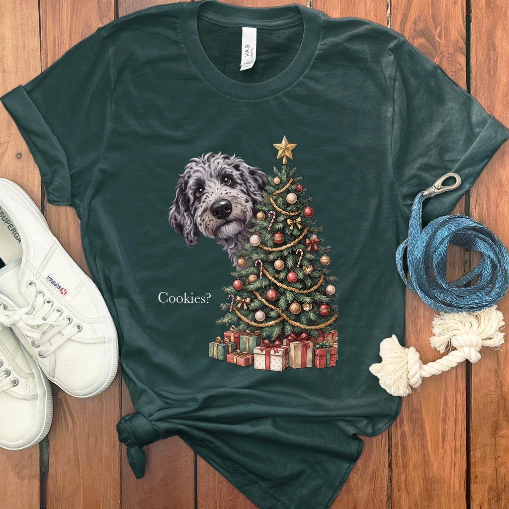 A dog peeks from behind a decorated Christmas tree and presents, asking "Cookies?".