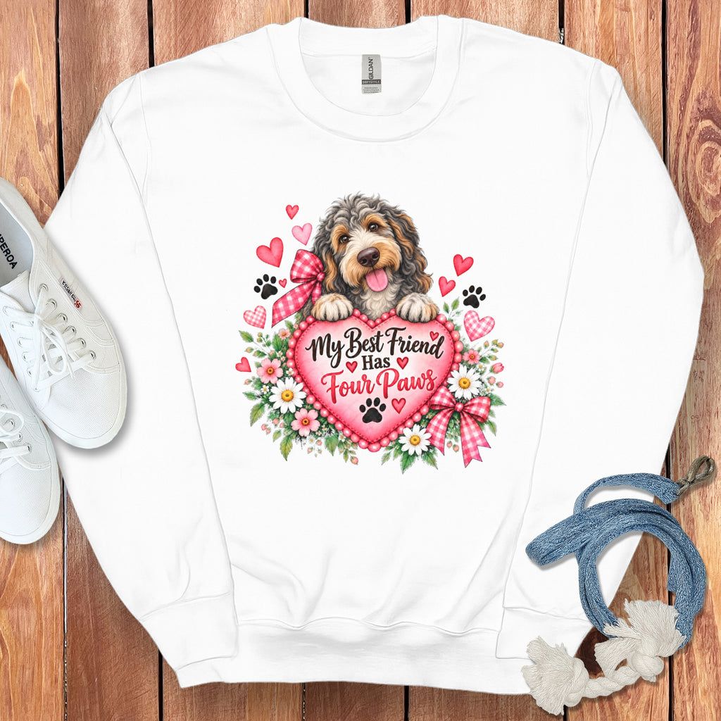 White crewneck sweatshirt with a graphic of a dog resting on a pink heart surrounded by flowers and the text My Best Friend Has Four Paws.