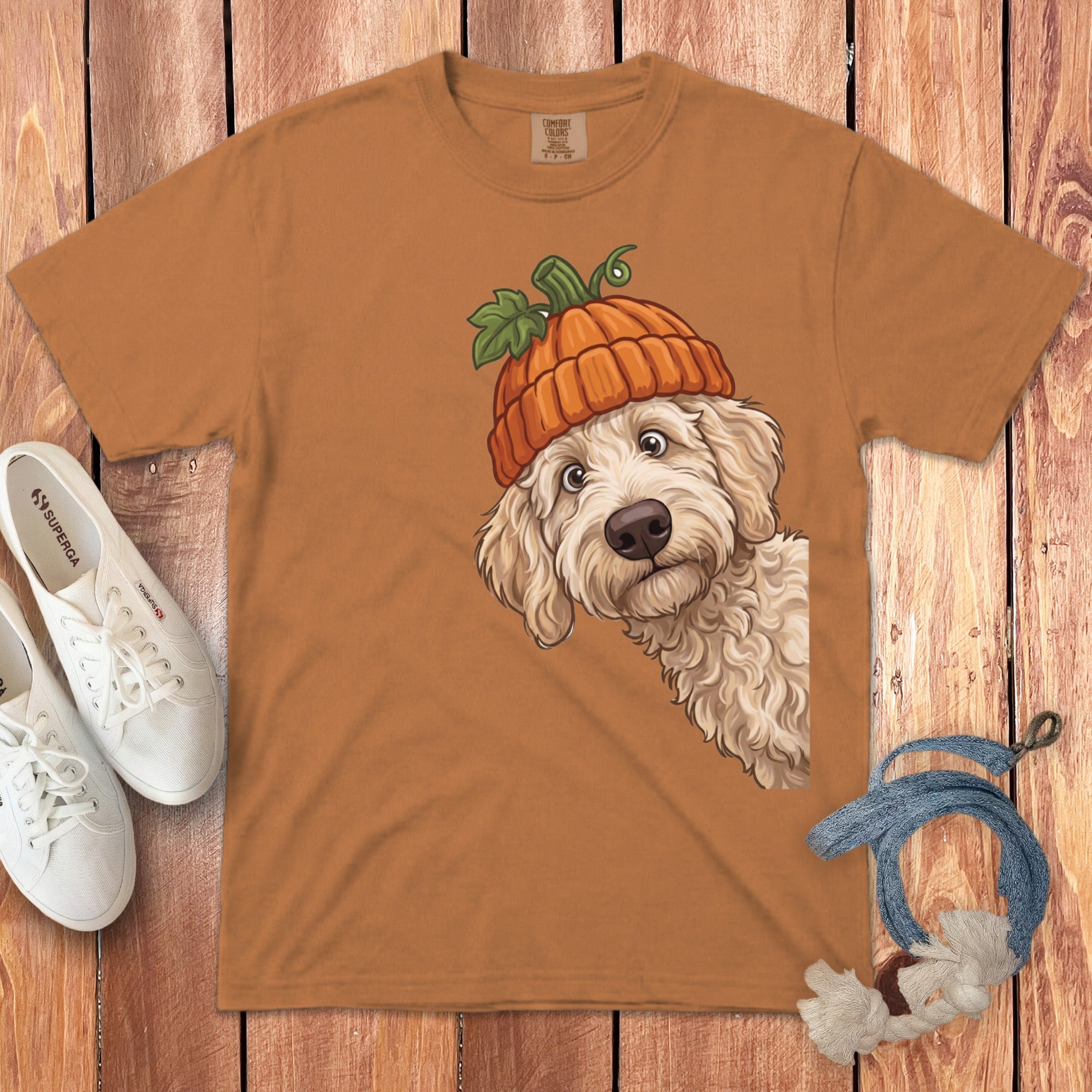 Orange t-shirt with cartoon dog wearing a pumpkin hat peeking from the side.