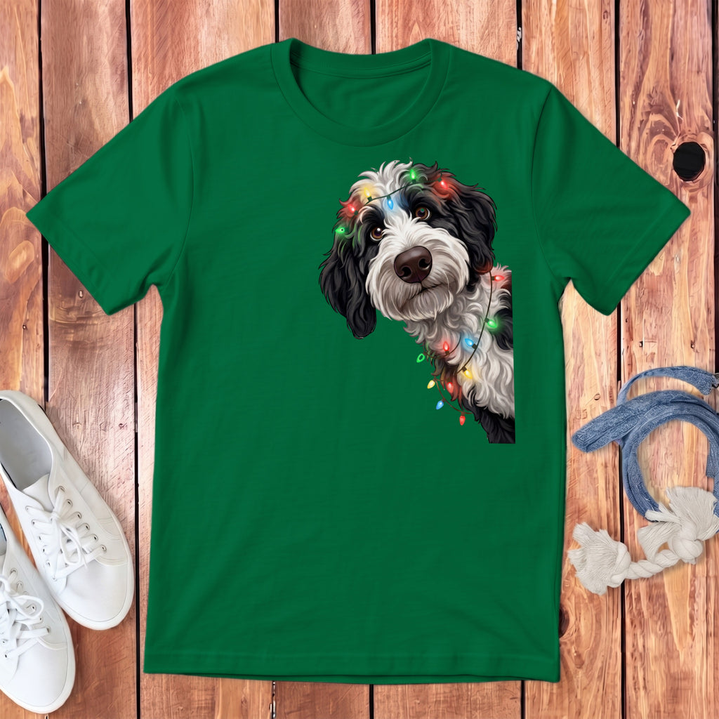 Green t-shirt with a black and white dog wearing colorful Christmas lights.