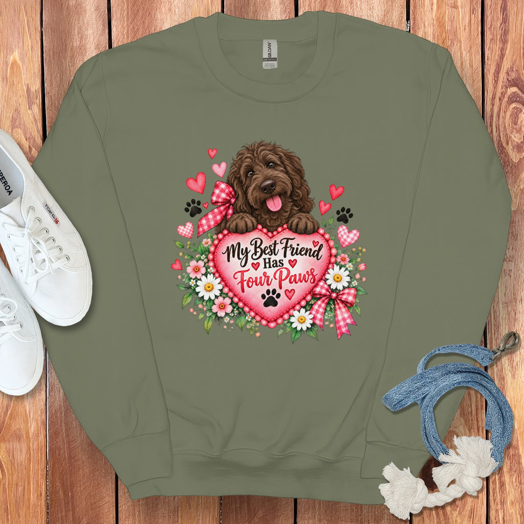 An olive green crewneck sweatshirt featuring a brown dog graphic with the text My Best Friend Has Four Paws surrounded by hearts and flowers.