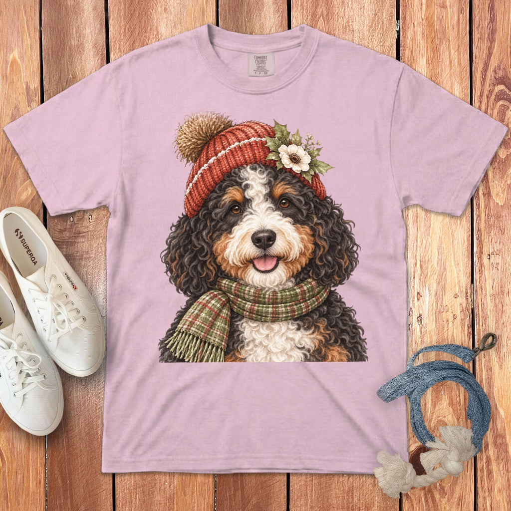 Bernese Mountain Dog wearing a red pom-pom hat and green plaid scarf.