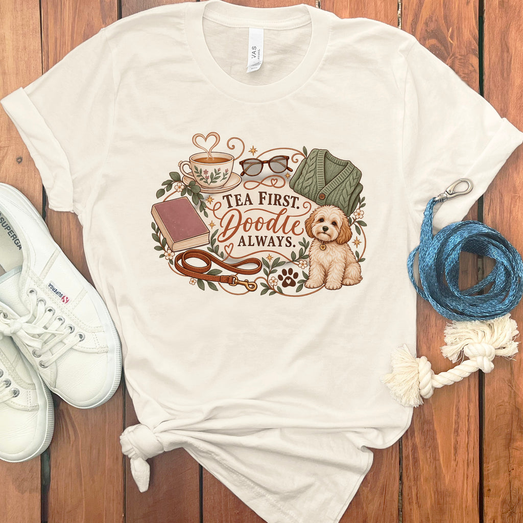 Cream t-shirt with "Tea First. Doodle Always." text and doodle illustration.