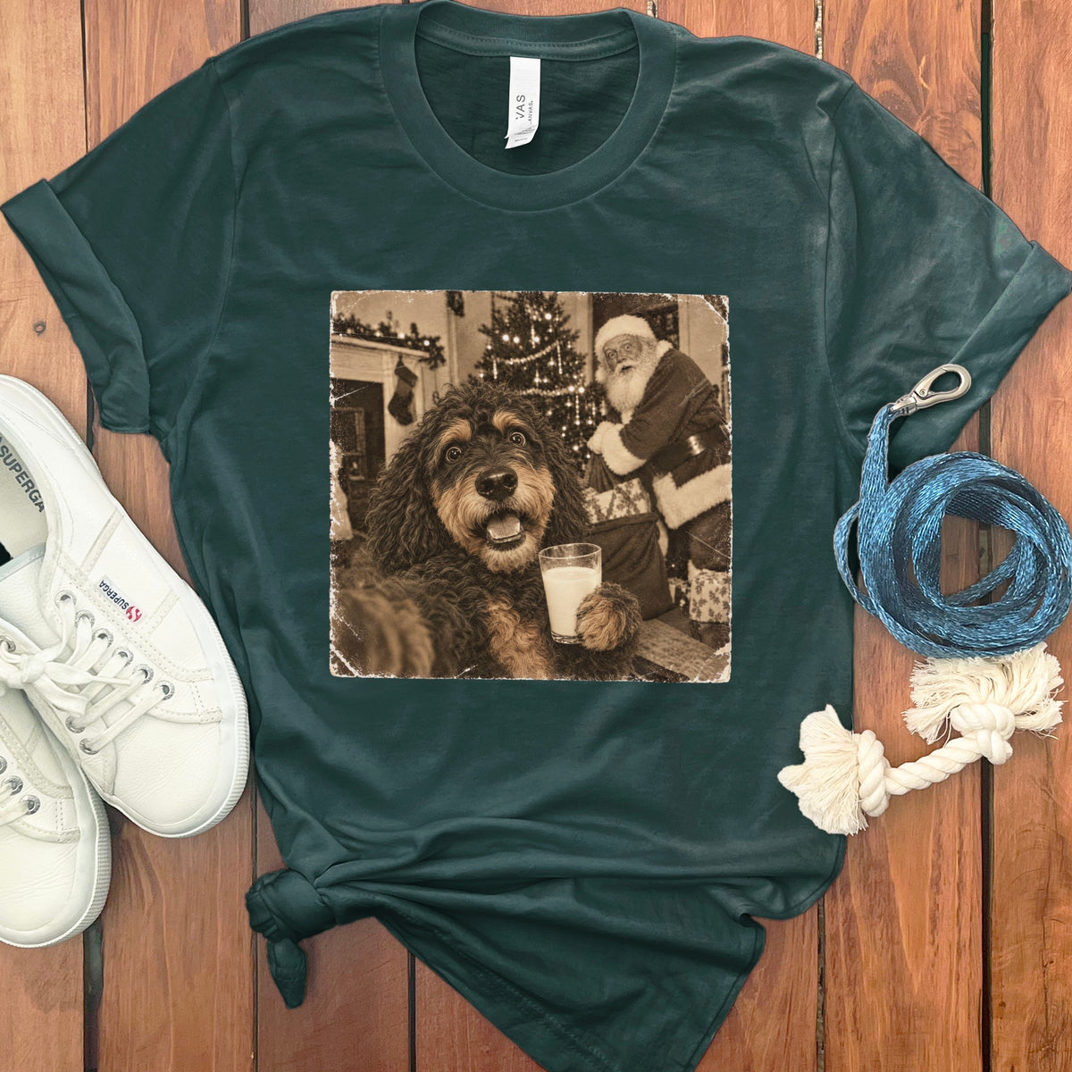 Dark green t-shirt with a vintage-style graphic of a fluffy dog holding a glass of milk with Santa Claus in the background.