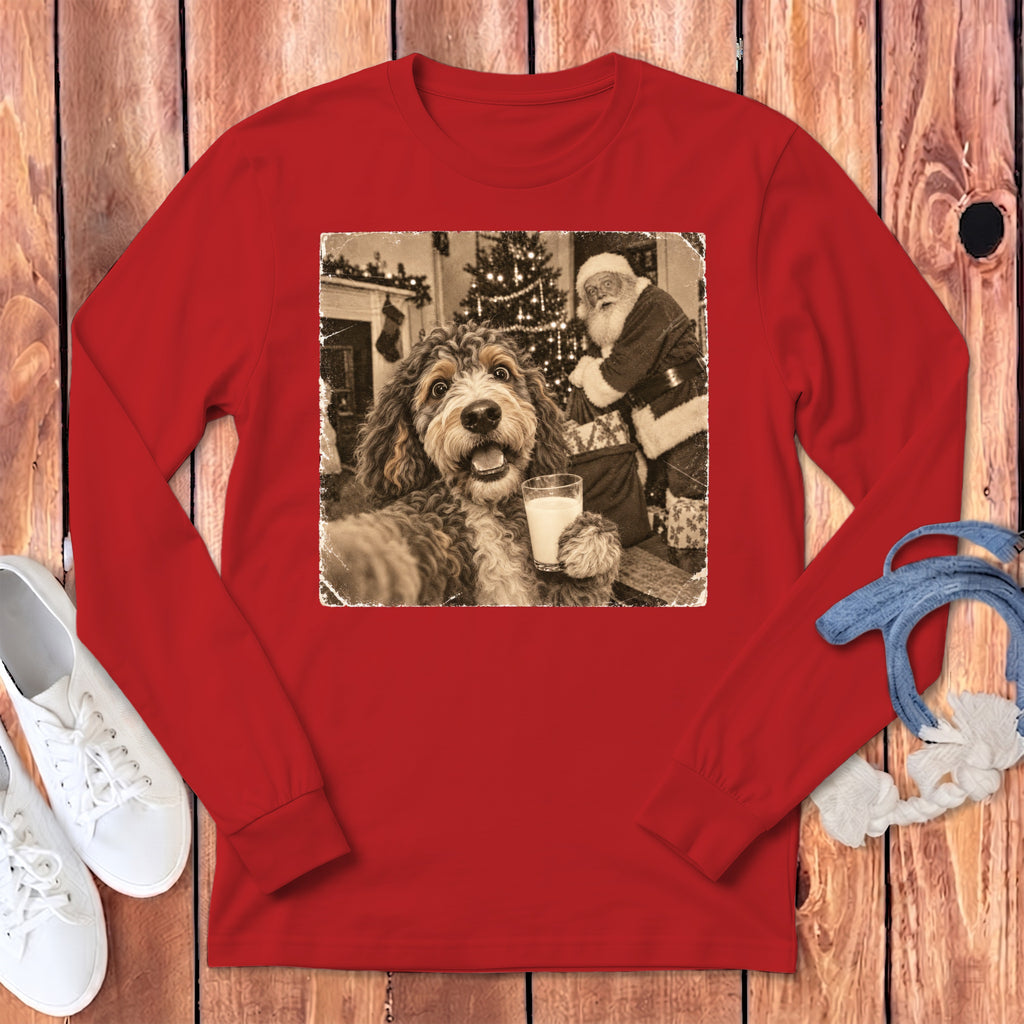 A red long-sleeve shirt featuring a graphic of a fluffy dog holding a glass of milk with Santa Claus in the background.