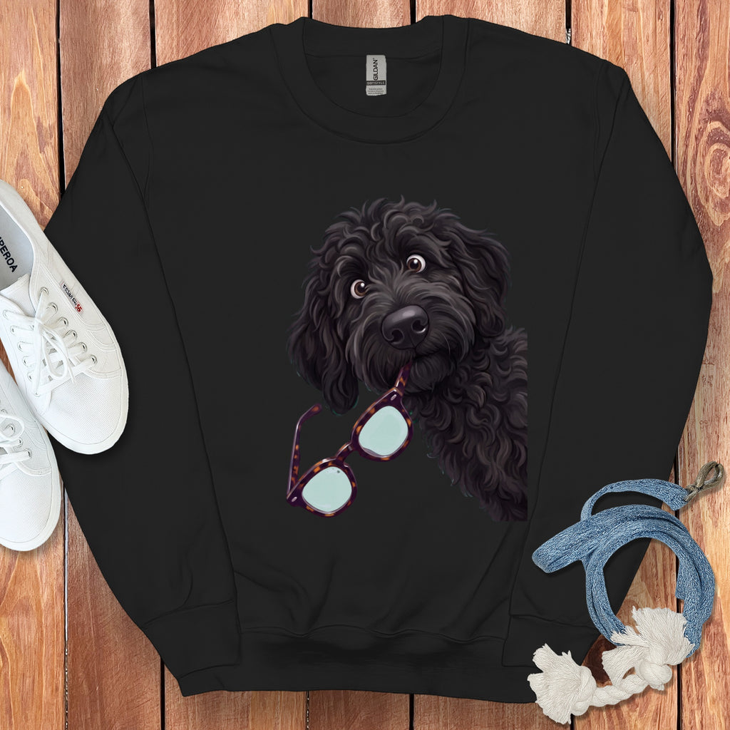 Black crewneck sweatshirt featuring a graphic of a black doodle dog holding glasses in its mouth.