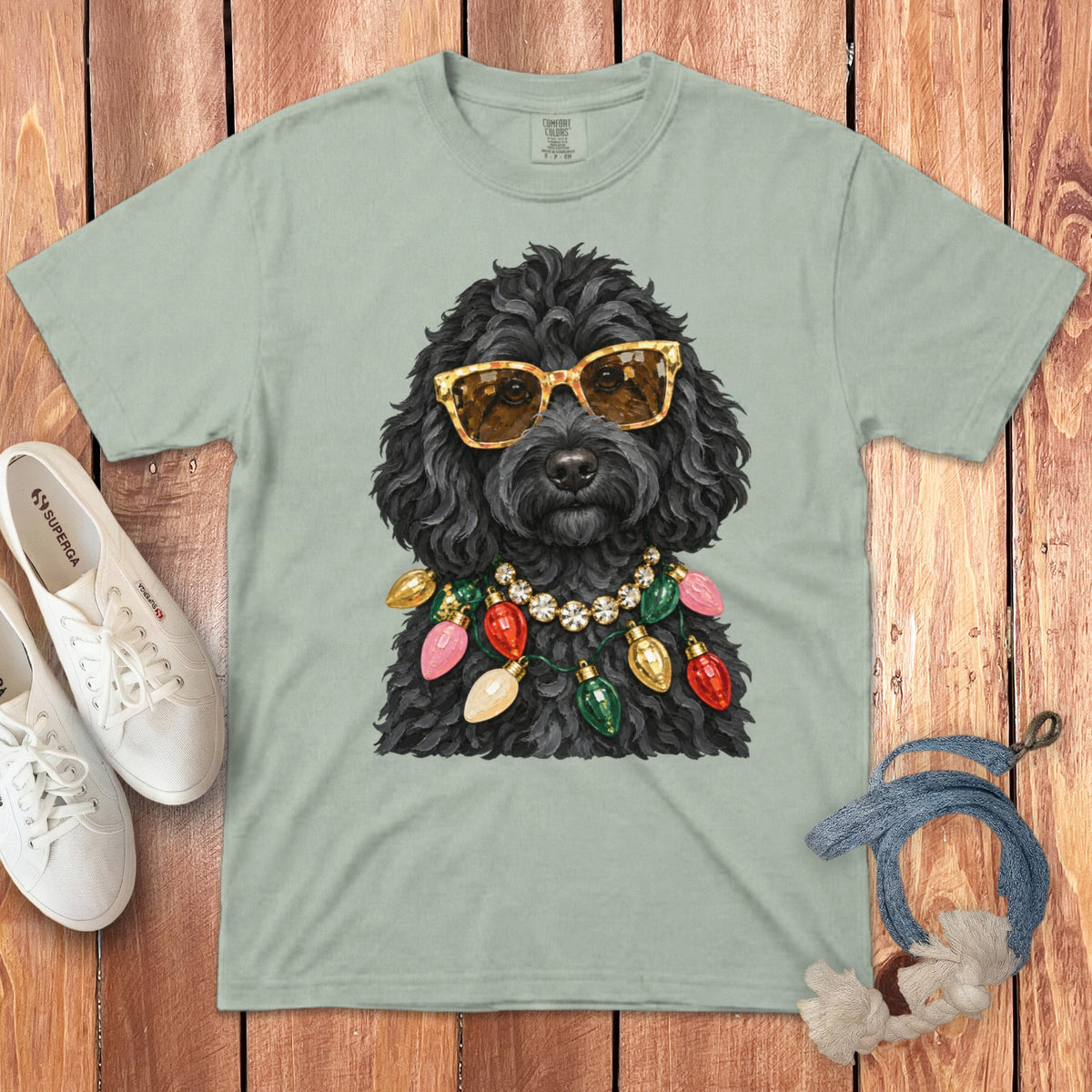 Black poodle wearing sunglasses and a Christmas light necklace.